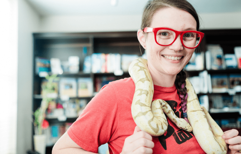 Girl in red shirt with large snake around her neck at Creepy Crawly Day